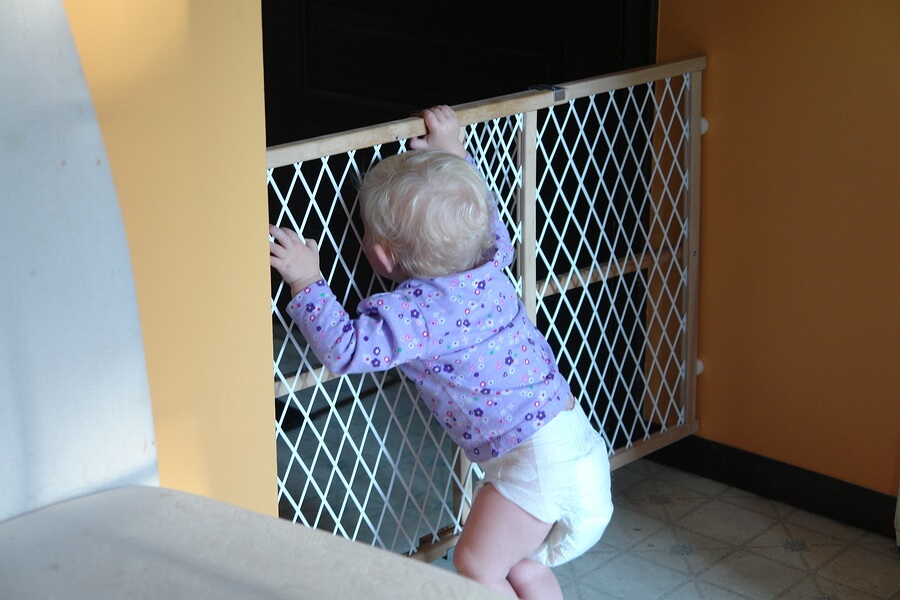 toddler standing at baby gate