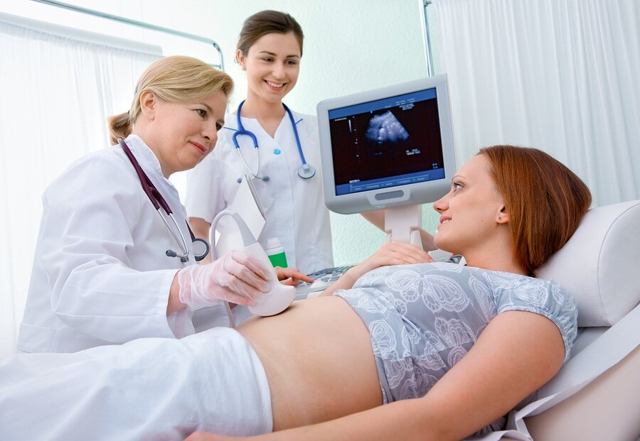 Pregnant woman at doctoe appointment getting ultrasound