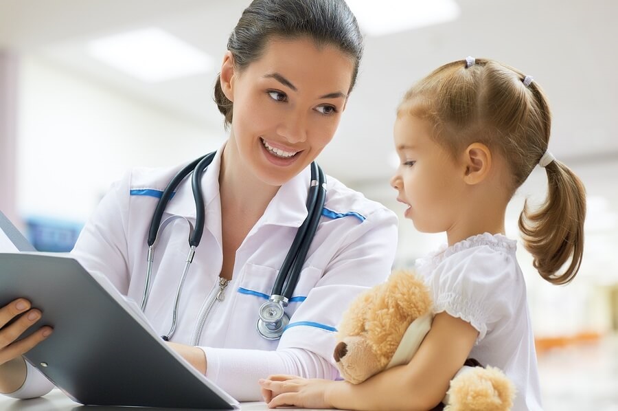 Doctor examining little girl at hospital