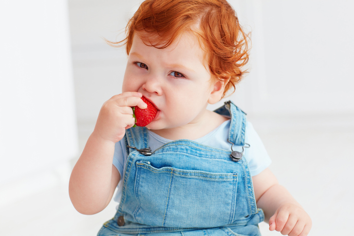 toddler baby eating strawberries 