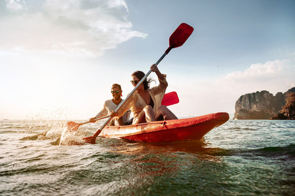 couple having fun kayaking on kids free vacation