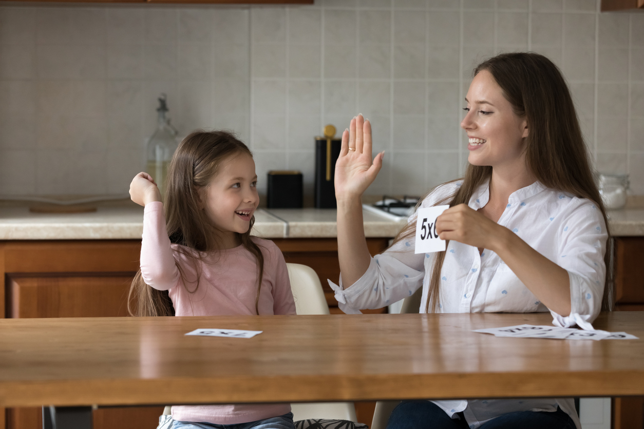 Mother give high five to daughter praising for multiplication