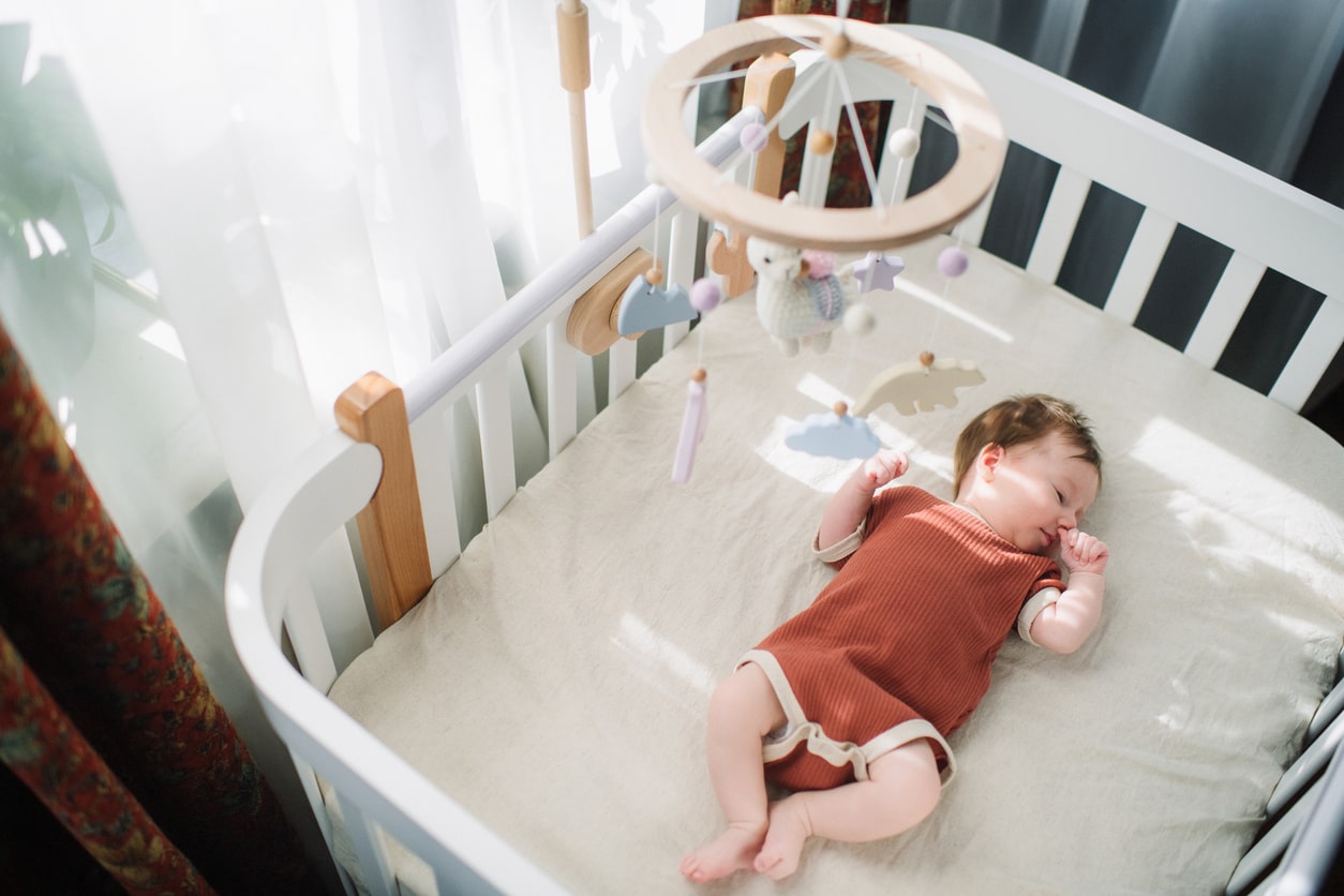 Baby asleep in crib, LeapFrog baby monitor nearby