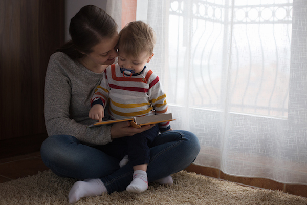 Popular named baby reading book with mom