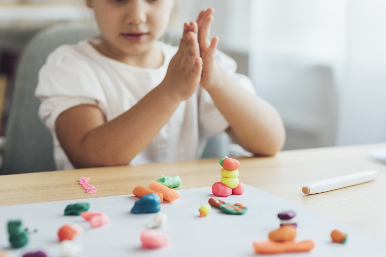 Preschooler Activities: Hands of a Little Girl Playing With Plasticine Making Shapes and Animals, a Close Up stock photo