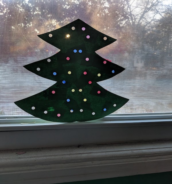 Completed Paper Christmas Tree Craft Taped Against A Window