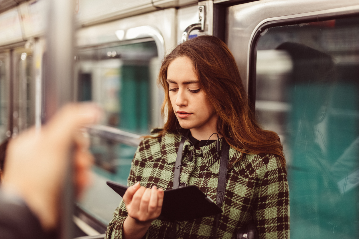 Woman reading e-book in the subway stock photo