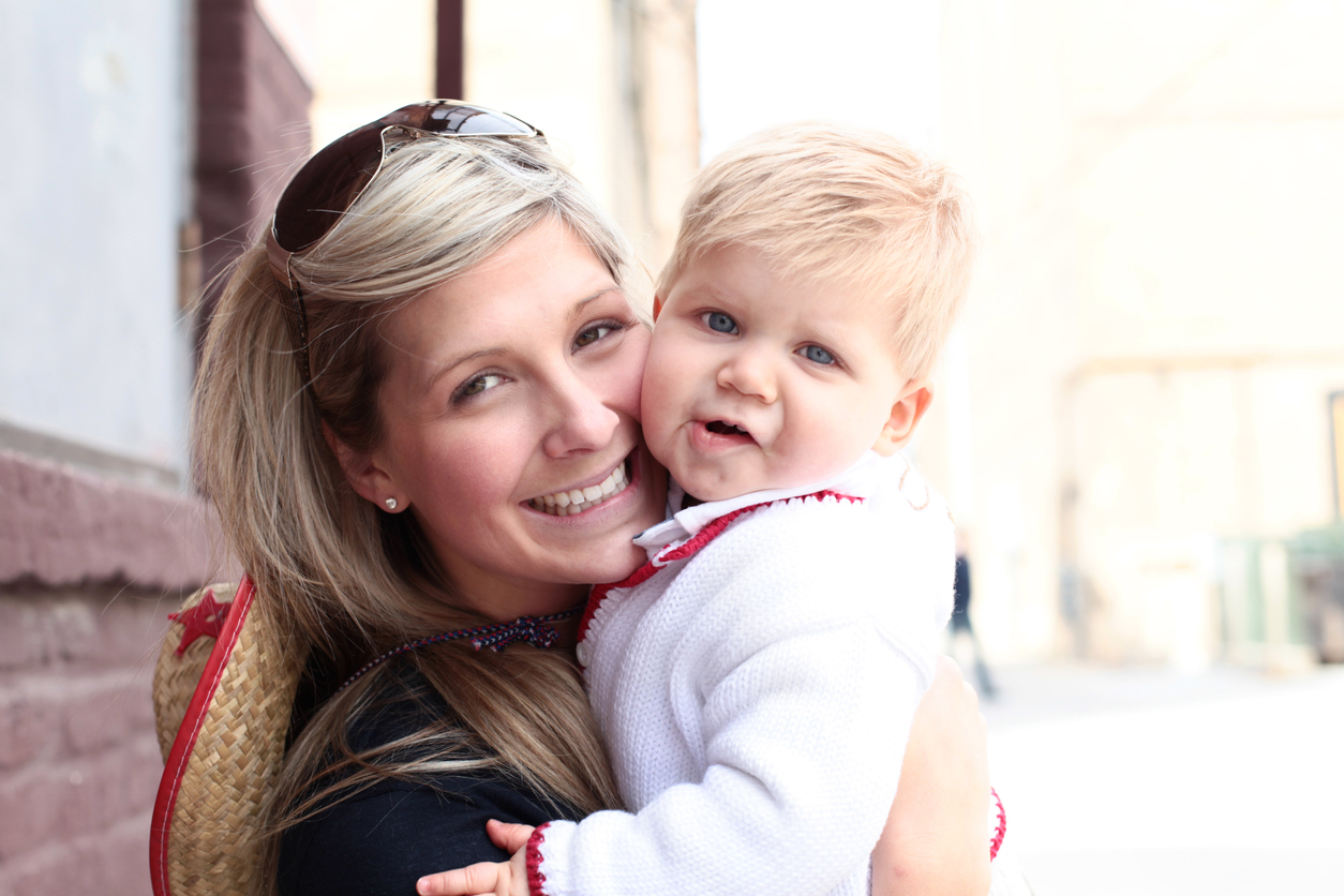 "Smiling young mother with her 12 month old son, looking at the camera, blonde."