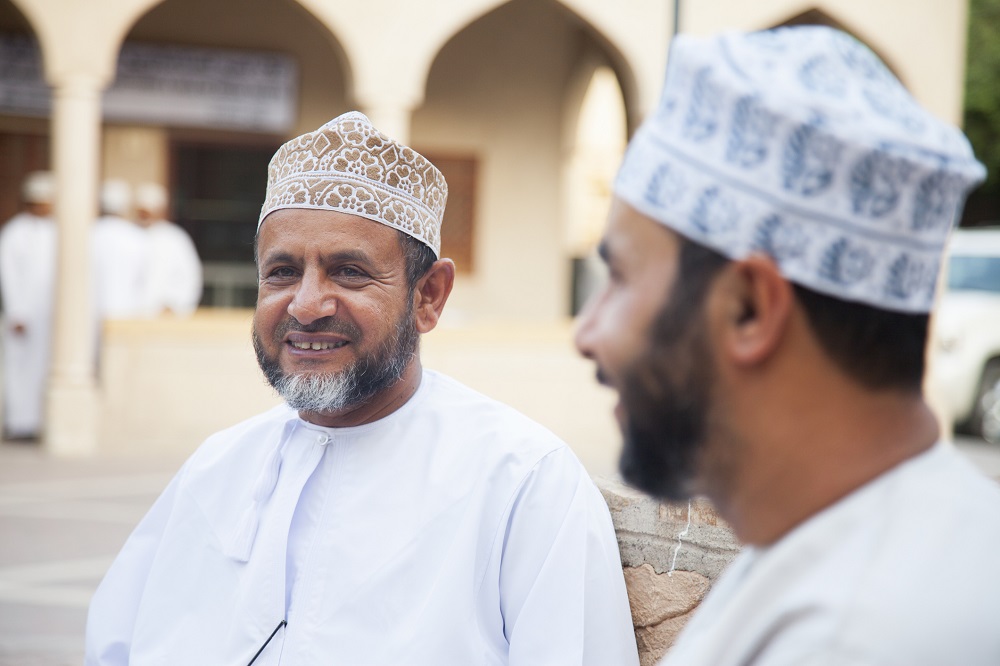 Men talking outside and looking friendly, Nizwa, Oman 