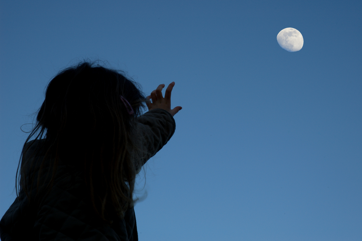 Little girl looks up at the moon 