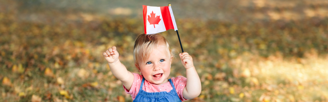 Baby girl holds Canadian flag, smiling