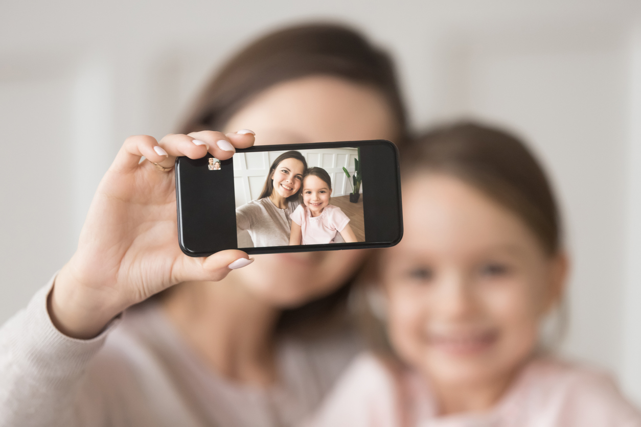 Mother and daughter smile for a selfie, post on social media
