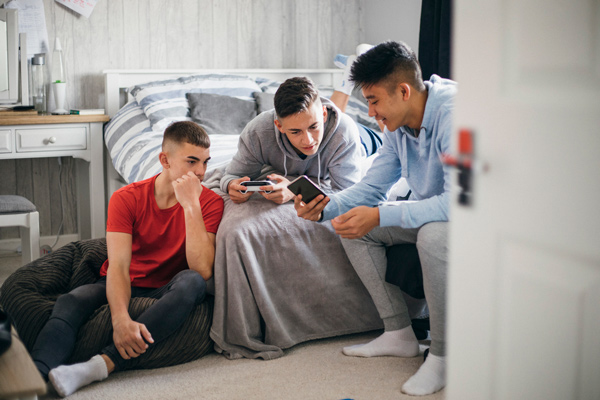 Teenage boys looking at Snapchat app on friend's phone