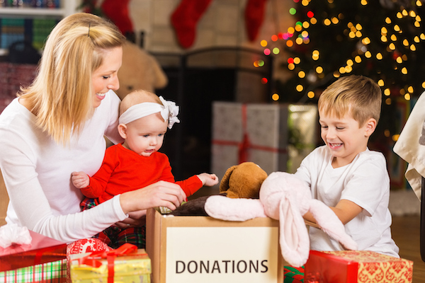 Boy toddler and infant helping their mom with Christmas donations