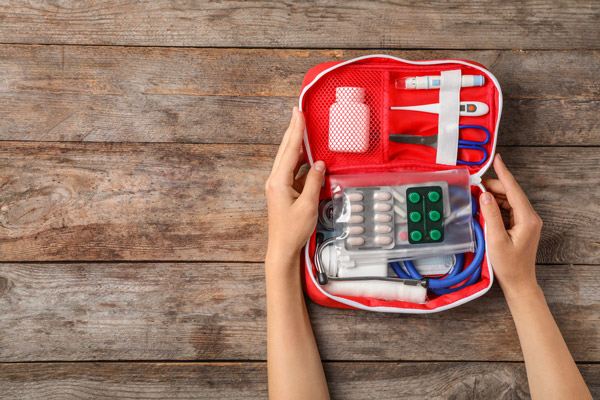 Young woman holding a first aid kit for chronically ill college student