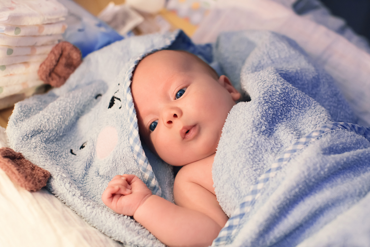 young baby wrapped in towel after sponge bath