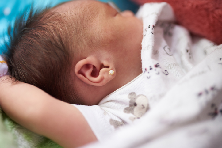 An infant baby wearing diamond earings