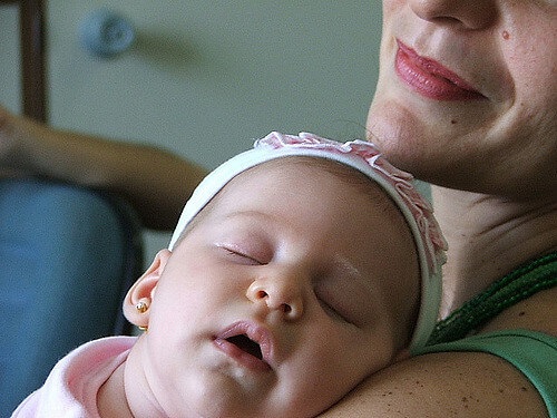 Baby girl sleeping on mother's shoulder
