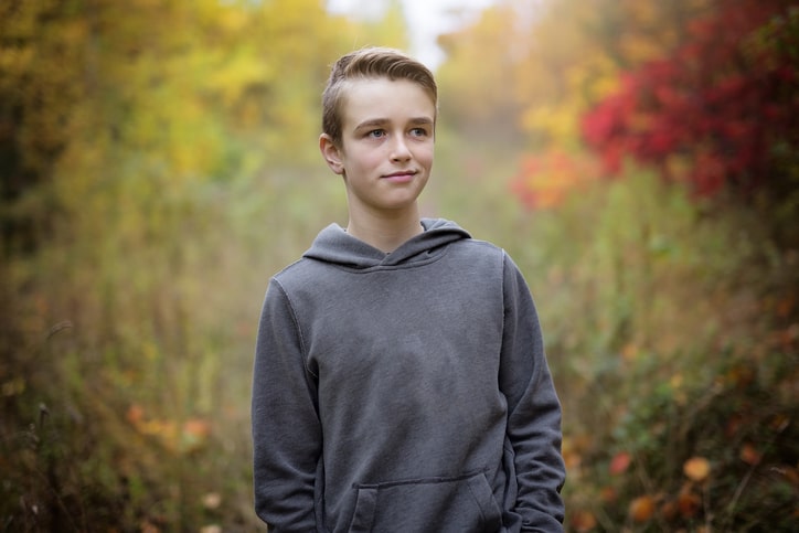 Middle school boy wears oversized grey hoodie, back to school outfit