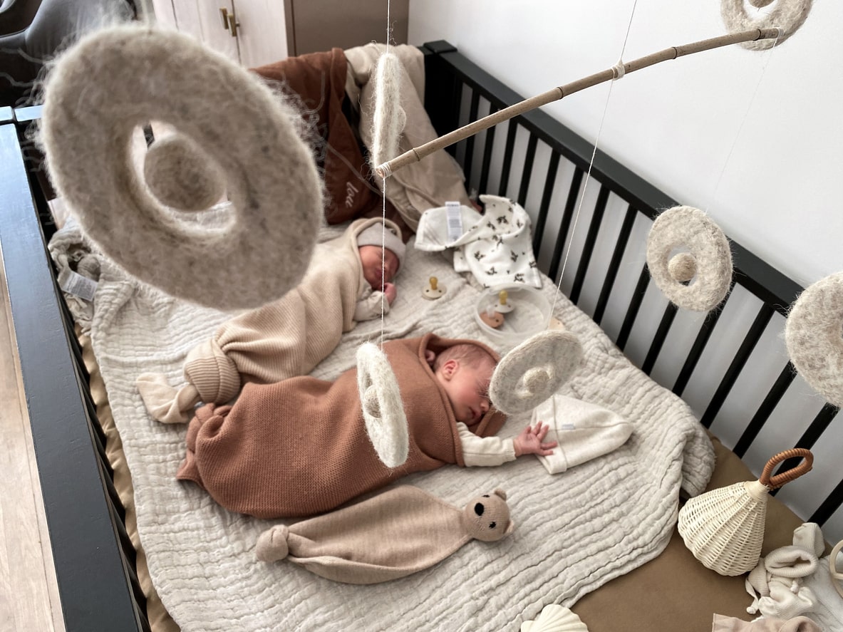 Baby twins sleeping in their beach-themed nursery.