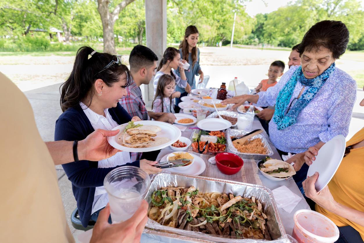 Large family enjoys fajitas at an outdoor family reunion.