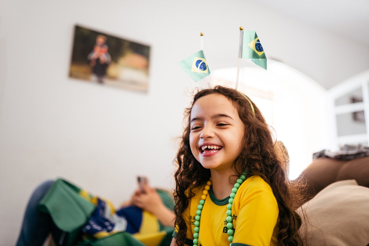 Smiling Brazilian girl watching soccer game