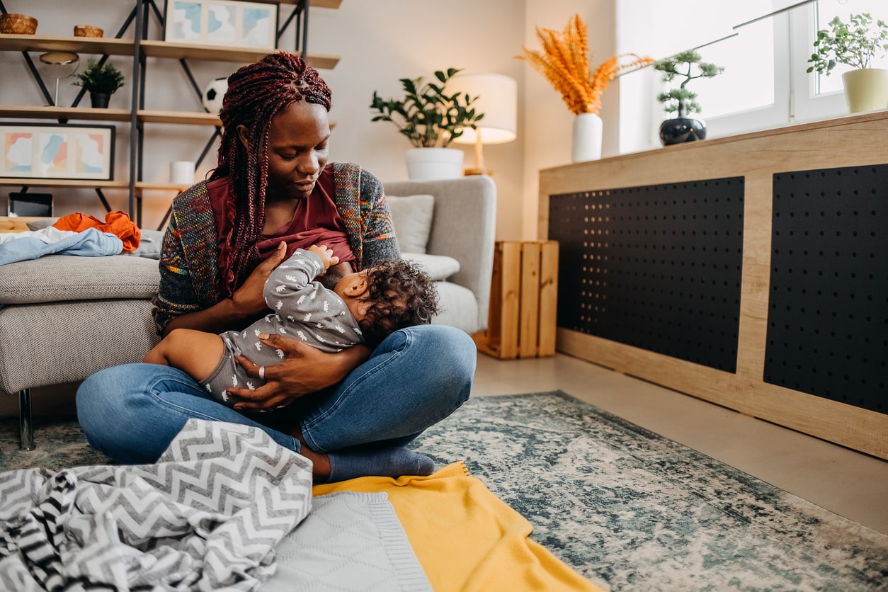 Mother breastfeeding her baby at home