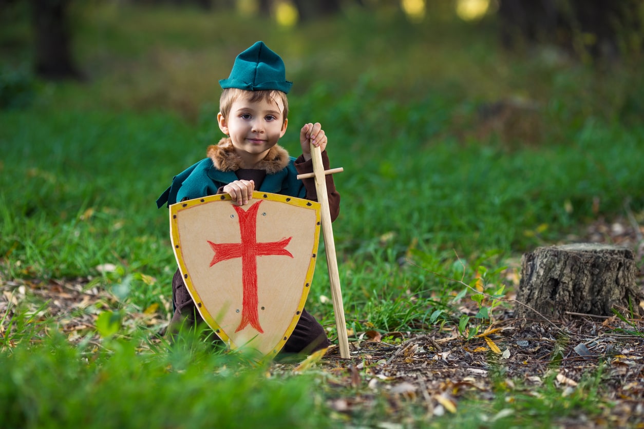 Young boy playing dress up as Celtic soldier outside. Celtic baby boy name concept