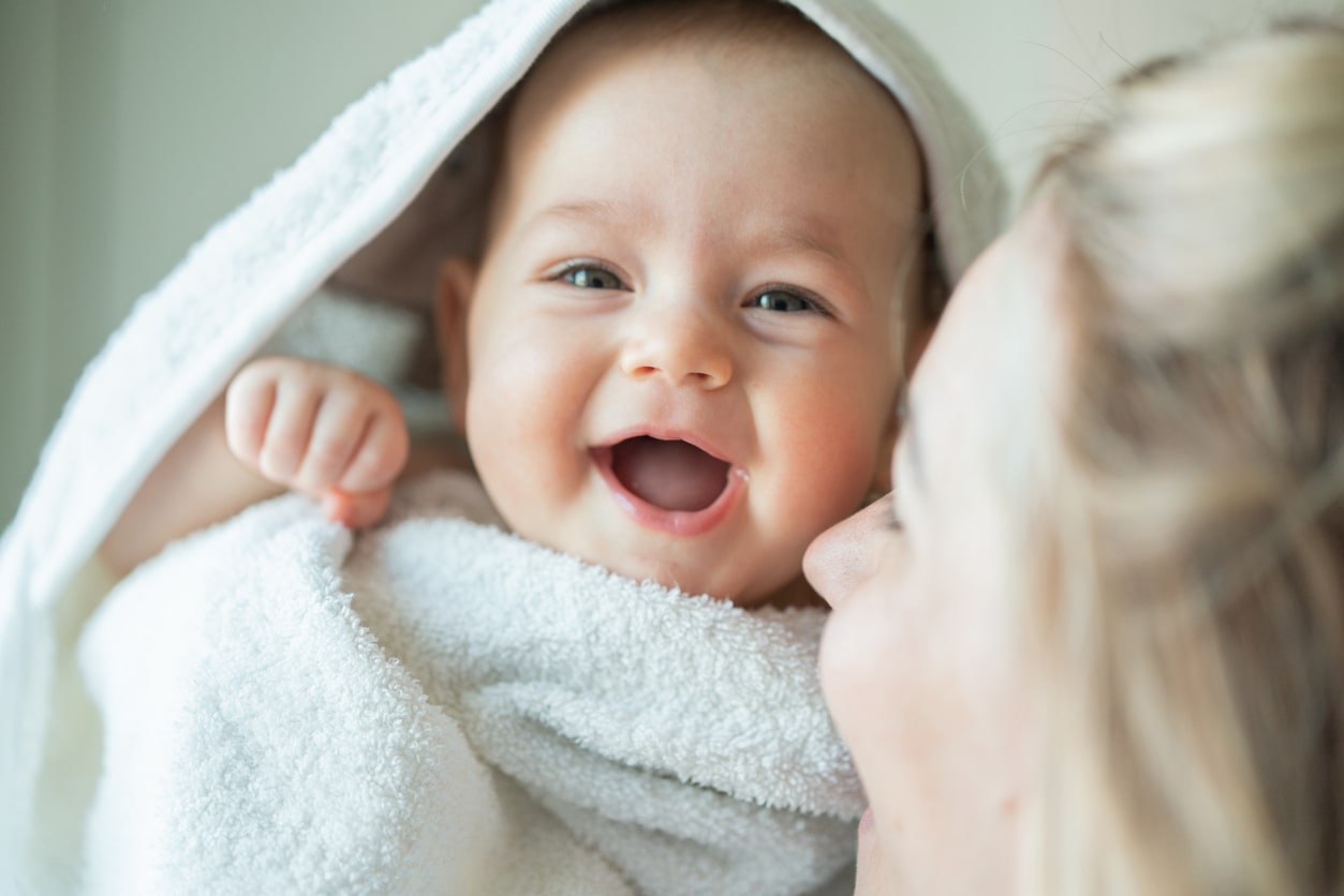 Happy baby girl wrapped in towel. Cute nicknames for girls.