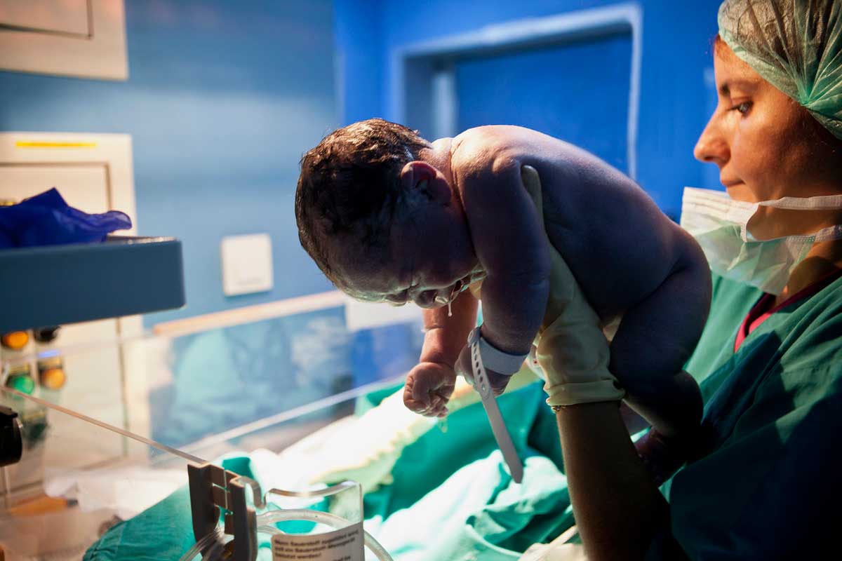 doctor holding baby minutes after birth