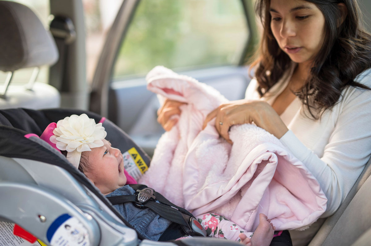 mom soothing crying baby in car