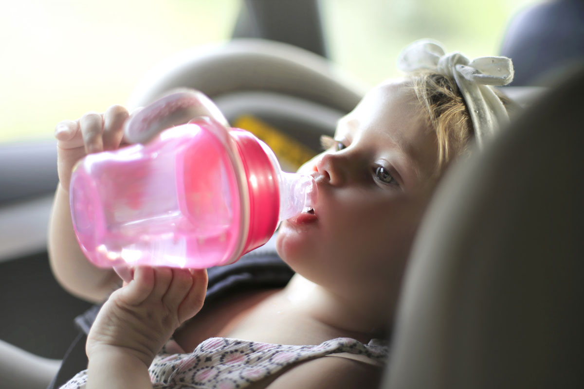 baby drinking from bottle in car
