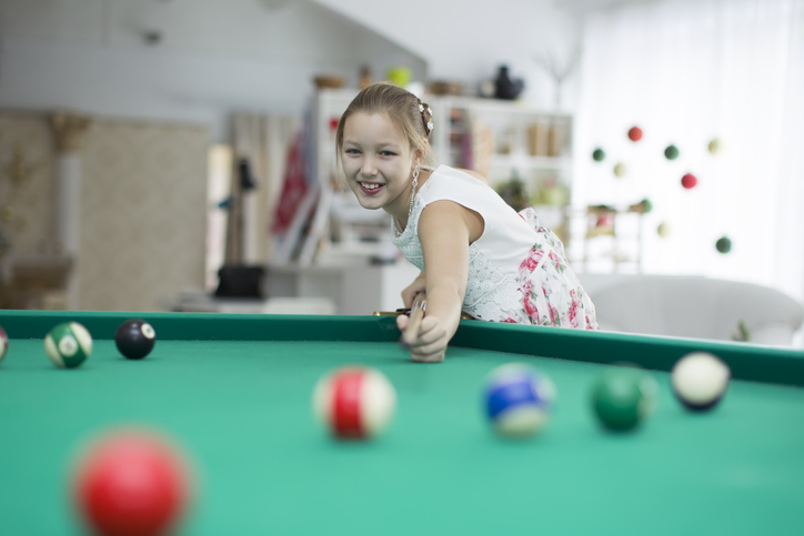 girl playing pool and smiling 