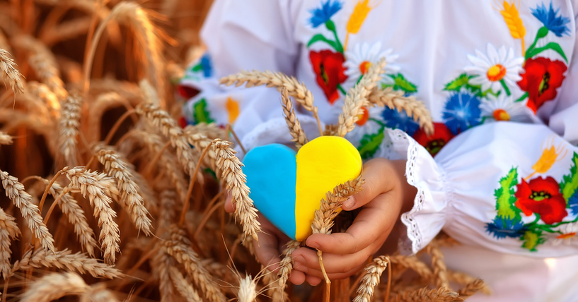 holding a heart painted in Ukrainian flag colors