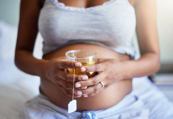 pregnant woman holding tea