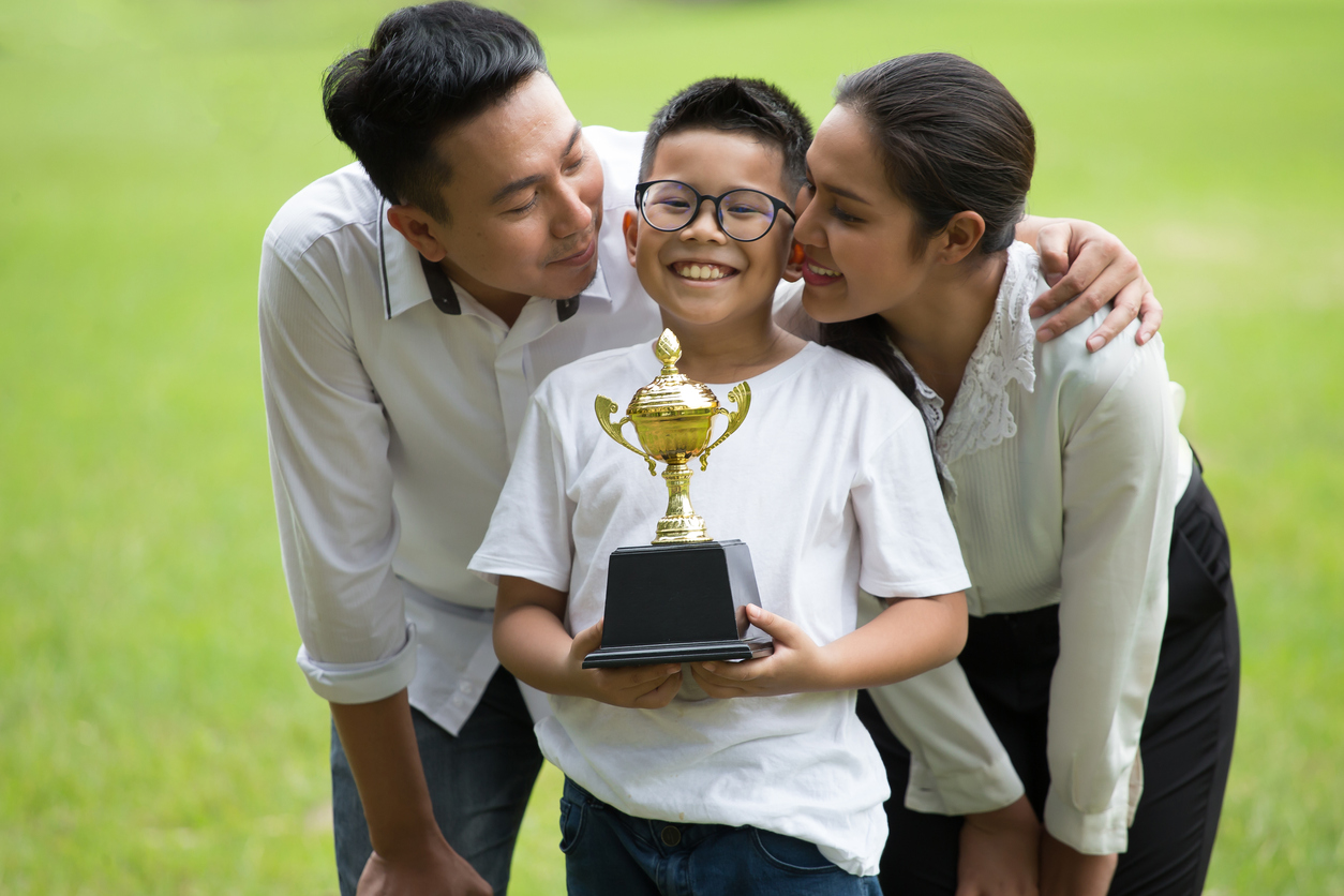 happy asian Family, parents and their children holding trophy in park together. 
