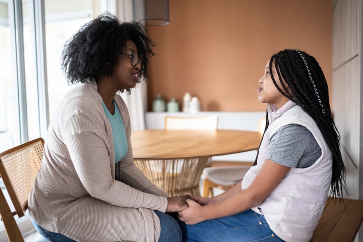 Mother and daughter sit at the kitchen table to discuss boundary settings and how to avoid toxic friendships