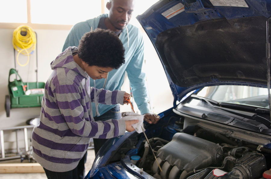 Teen learning car maintenance 
