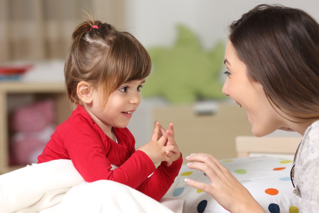 Mother and daughter using baby sign language to communicate