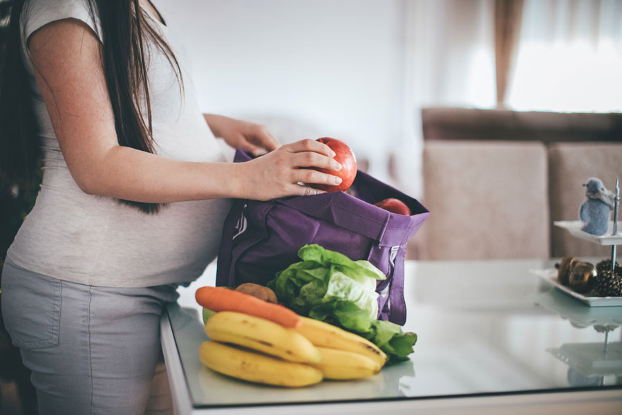 Pregnant women packing healthy snacks for a day at the beach
