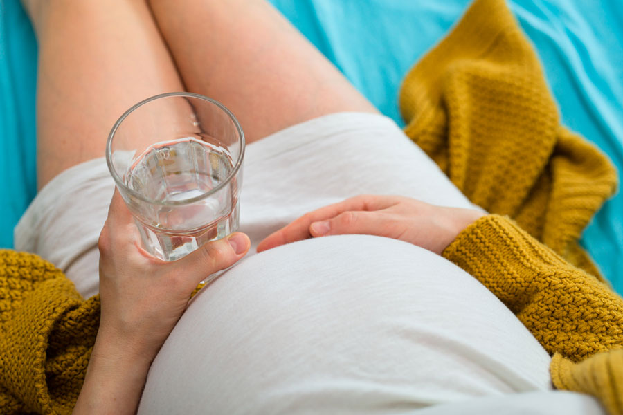 Pregnant woman holding a cup of water