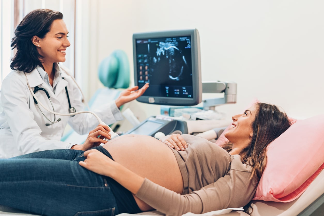 Pregnant woman in her third trimester gets ultrasound at the doctors office. Labor approaching. 