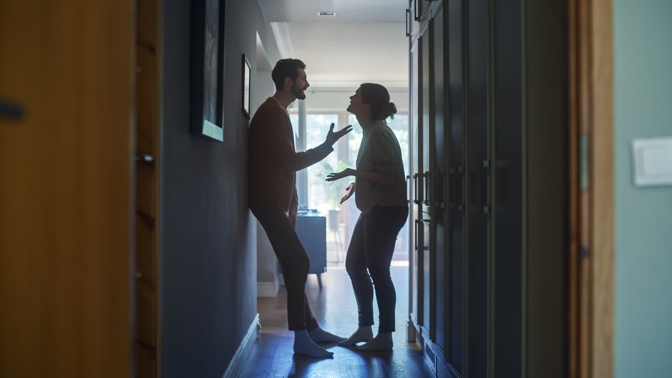 Two parents arguing in the hallway.