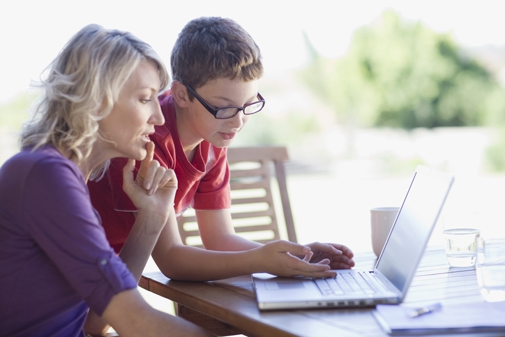 mother looking at her son's laptop