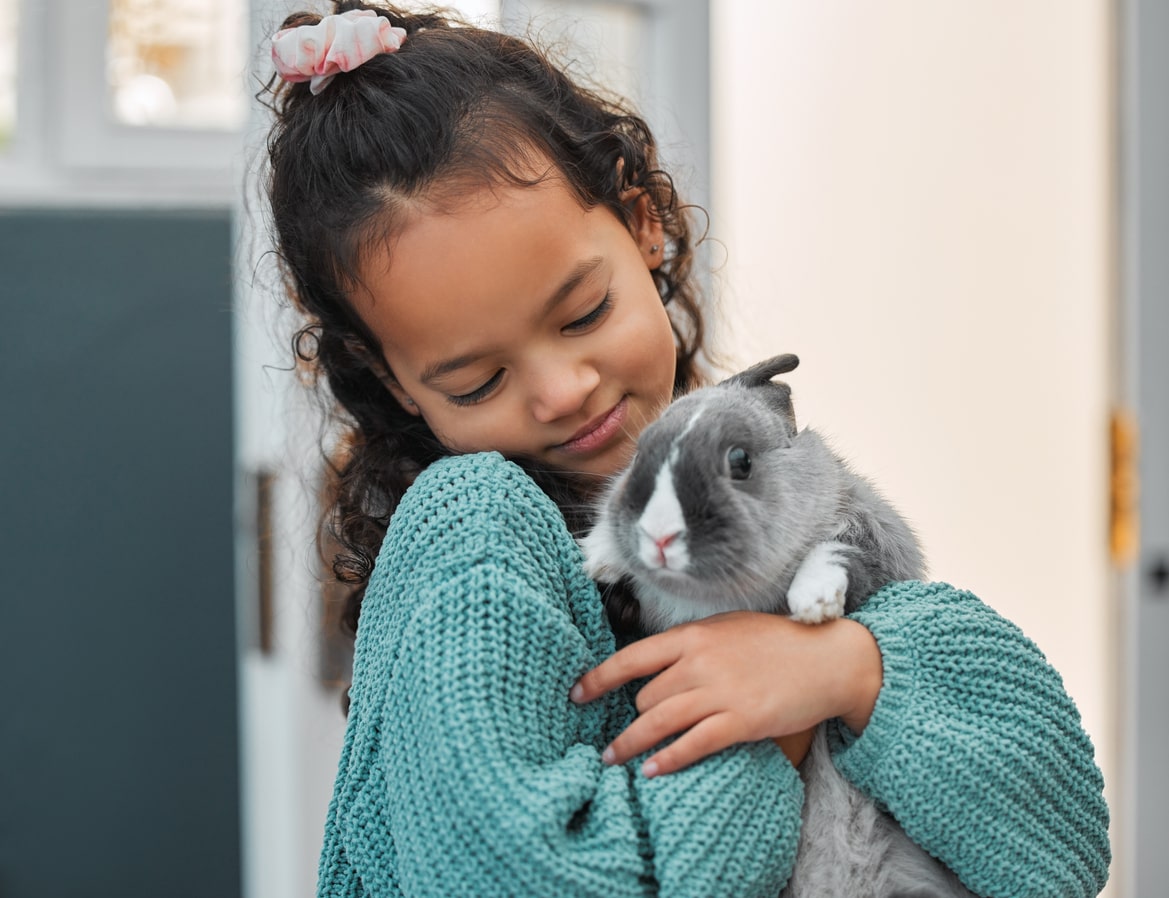 Shot of an adorable little girl bonding with her pet rabbit at home