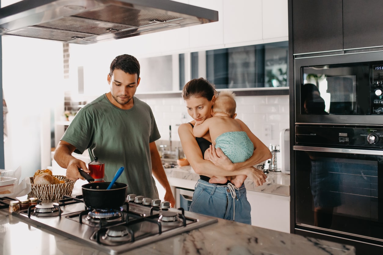 New parents cooking healthy postpartum meal in kitchen