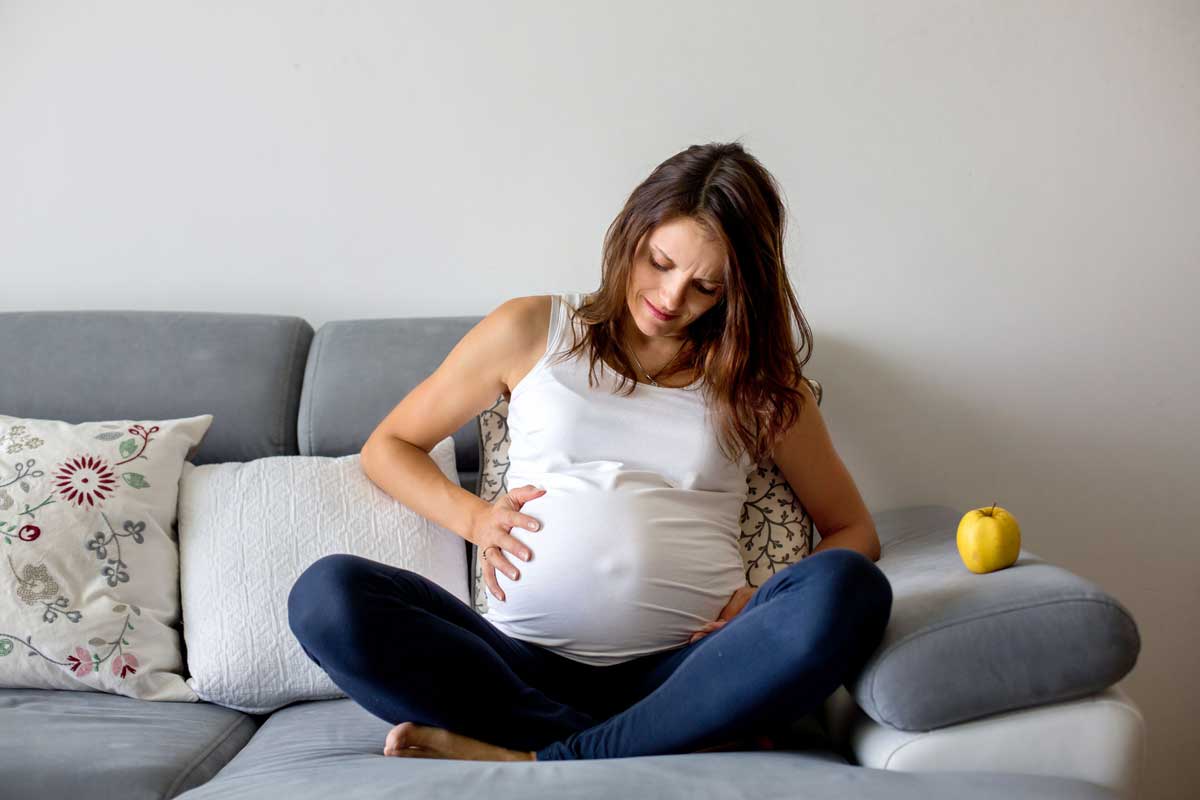 pregnant woman having contraction on couch