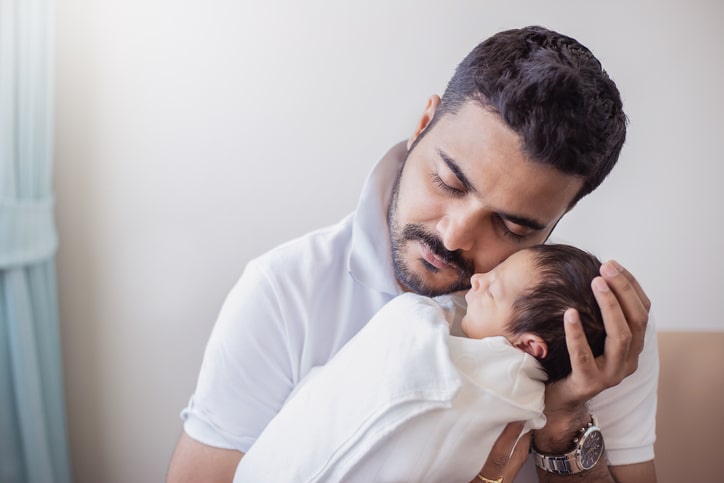 Dad holds newborn baby; skin-to-skin contact