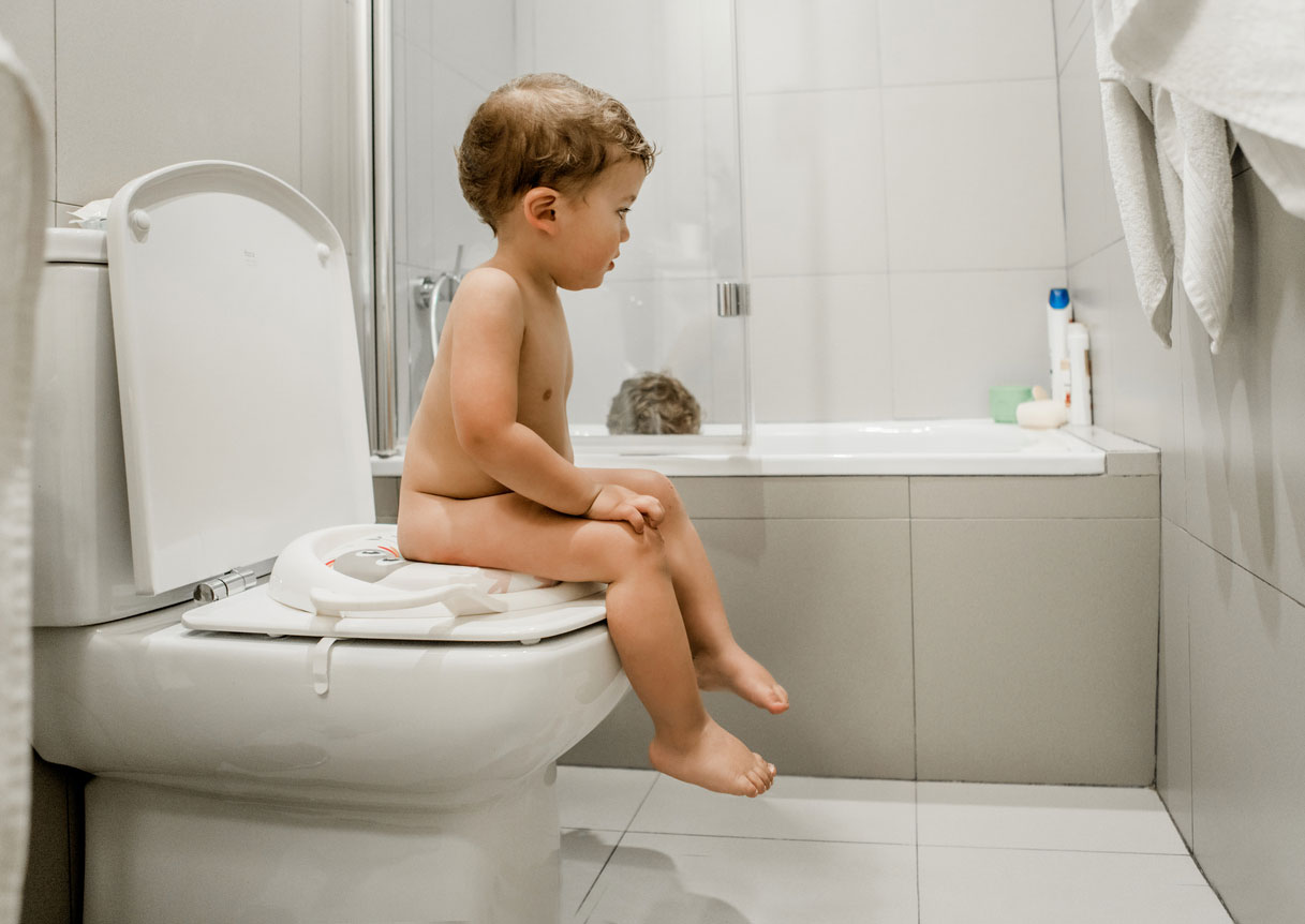 toddler sitting on toilet