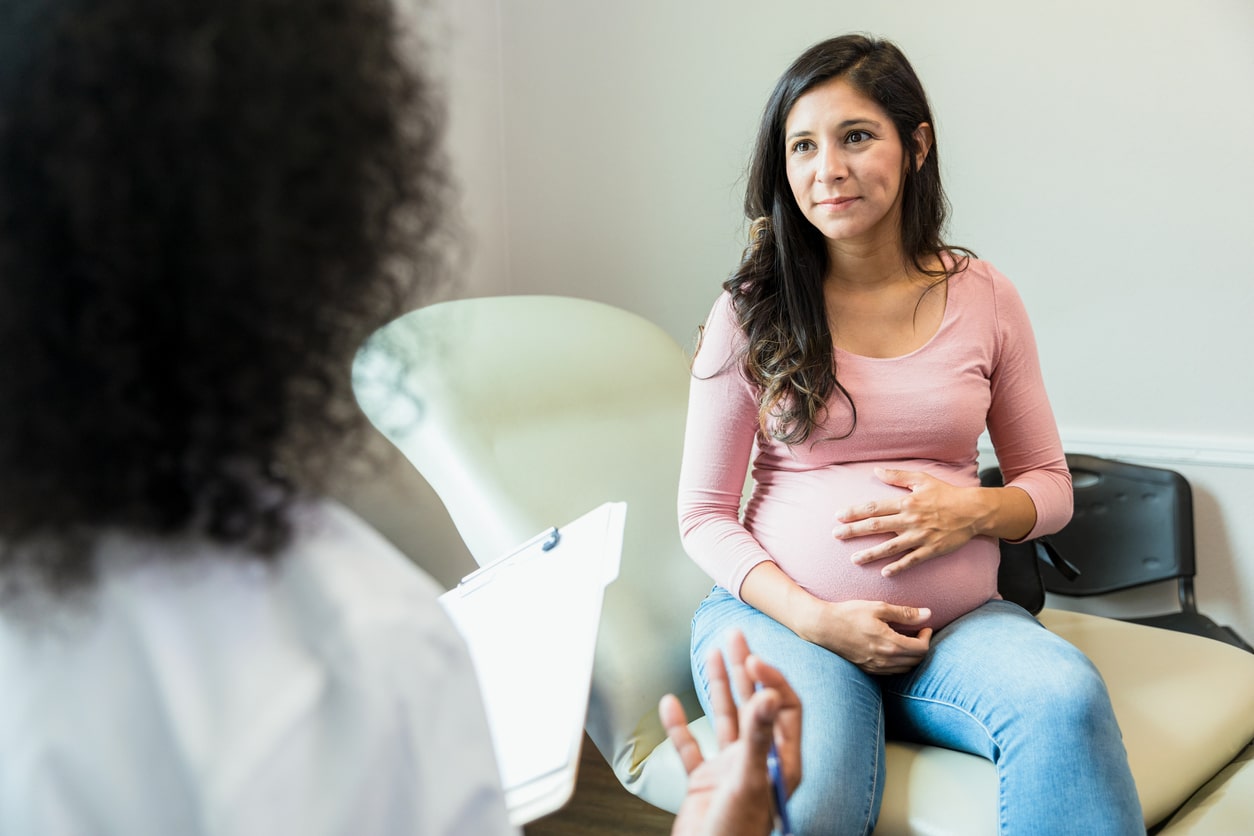 Pregnant woman at the doctors for suspected stress urinary incontinence.